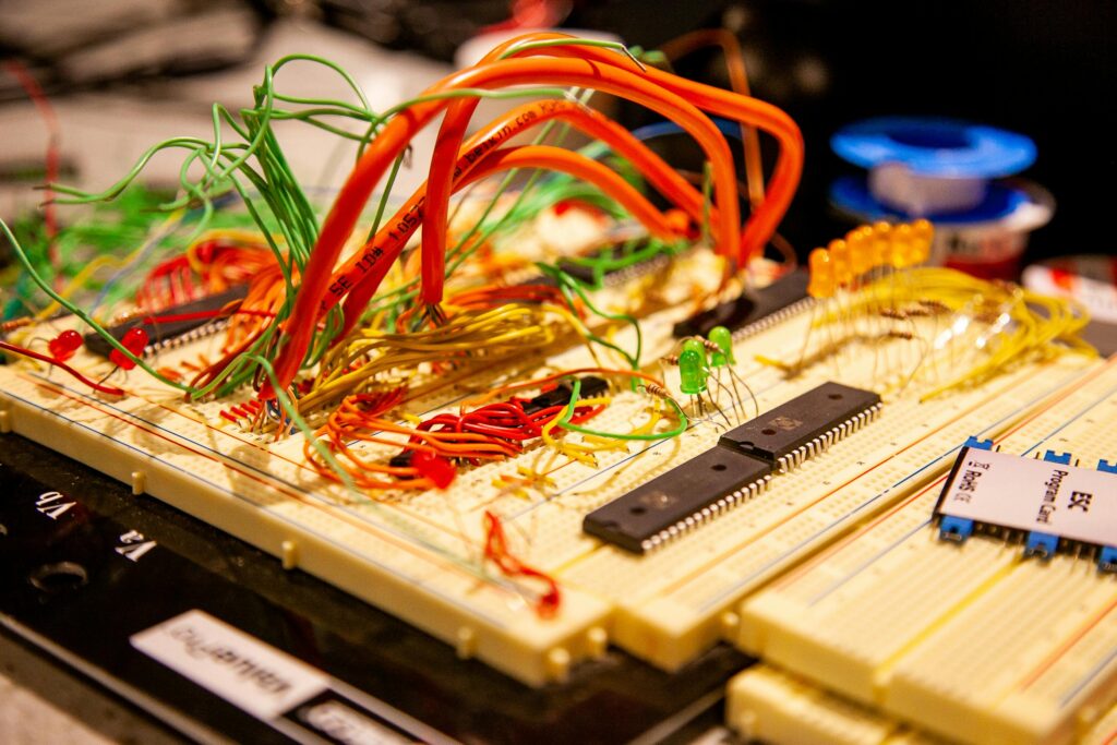 pexels photo 11447064 11447064 Vibrant breadboard with multicolored wires and electronic components in a detailed close-up.