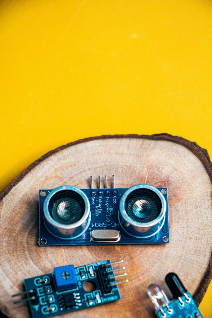 pexels photo 35686430 35686430 Close-up of electronic modules on a wooden slice against a vibrant yellow background.